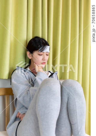 発熱で冷えピタを貼る女性 発熱で冷えピタを貼る女性 70658865