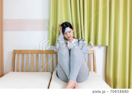 発熱で冷えピタを貼る女性 70658880