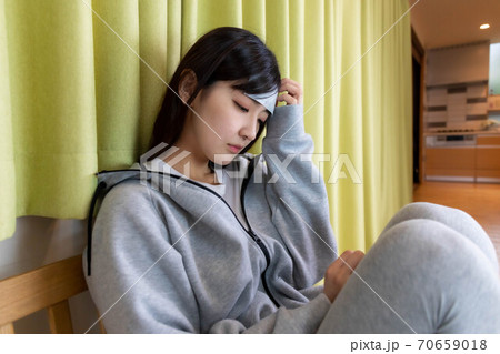 体調不良で欠勤の連絡をする女性 体調不良で欠勤の連絡をする女性 70659018