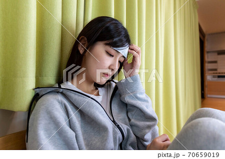 体調不良で欠勤の連絡をする女性 体調不良で欠勤の連絡をする女性 70659019