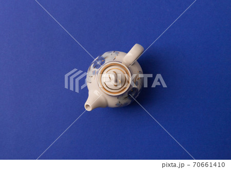 Tea in old fashioned kettle on classic blue background Tea in old fashioned kettle on classic blue background 70661410