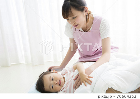 幼児を寝かしつける女性 70664252