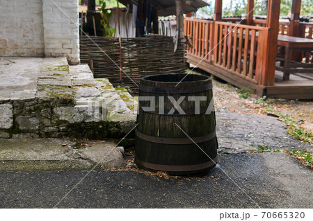 antique wooden water barrel stands by the porch 70665320