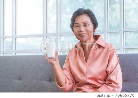 Asian senior woman is holding milk for calcium food and healthy lifestyle concept. 70665770