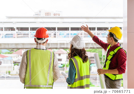 Three Civil engineers team with one female is discussing about transporation construction site 70665771