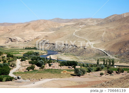 The Hari River (Harirud) near Chisht-e-Sharif in Herat Province, Afghanistan. The river flows past a small village in this remote part of western Afghanistan. Trucks are on the dirt road to Herat. 70666139