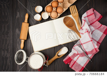 Recipe Cooking book, Wooden kitchen Utensils, eggs and flour on dark rustic wooden background. 70666184