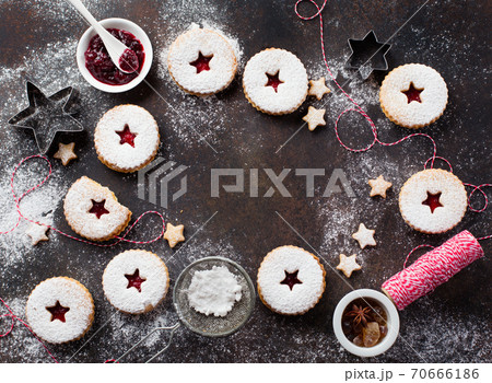Traditional Christmas Linzer cookies with raspberry jam on dark background. 70666186