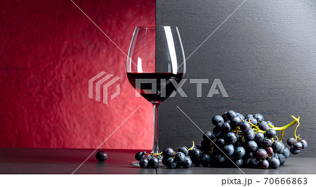 Red wine grapes on a black table and glass of red wine. Red wine grapes on a black table and glass of red wine. 70666863
