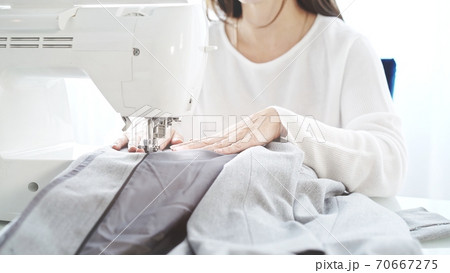 A female with white sewing machine, atelier sewing studio 70667275