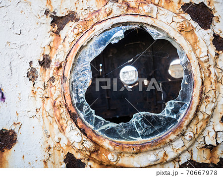 An old abandoned ship's porthole 70667978