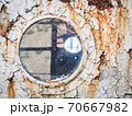 An old abandoned ship's porthole 70667982