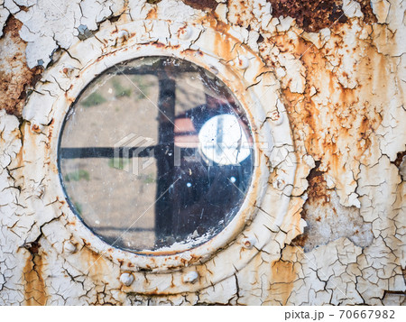 An old abandoned ship's porthole 70667982