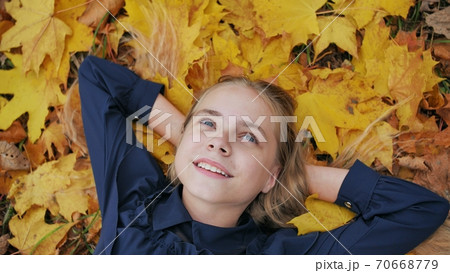 A young happy girl lies in the autumn leaves. 70668779