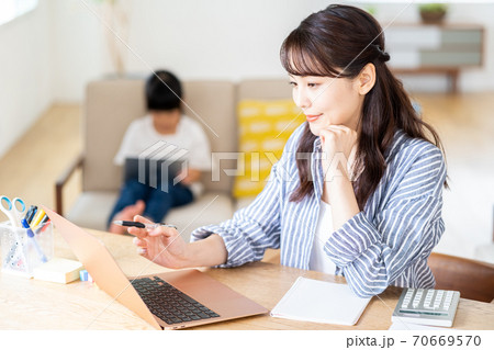 育児をしながらテレワークする女性(母子) 育児をしながらテレワークする女性(母子) 70669570