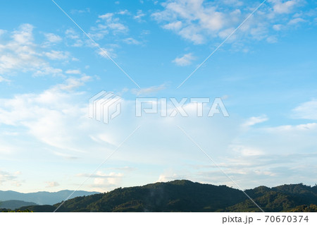 The white clouds have a strange shape and moutain. 70670374
