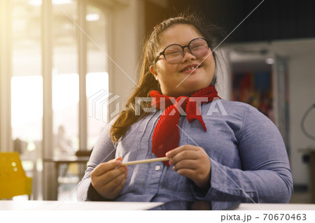 Happy Asian girl with Down's syndrome sit in classroom. Concept disabled kid learning. Happy Asian girl with Down's syndrome sit in classroom. Concept disabled kid learning. 70670463
