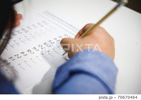 Close up mathematics homework of school children. Student doing quiz during math class. Close up mathematics homework of school children. Student doing quiz during math class. 70670464