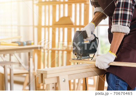 Man use jigsaw for woodwork in carpentry workshop. Man use jigsaw for woodwork in carpentry workshop. 70670465
