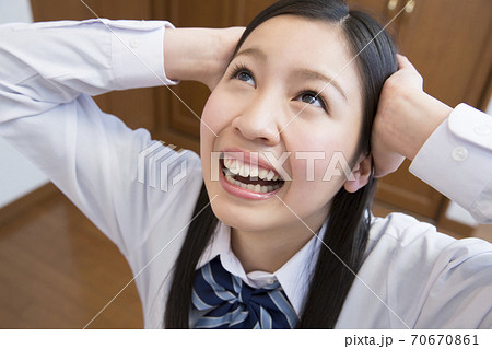 頭を抱える女子高校生 70670861