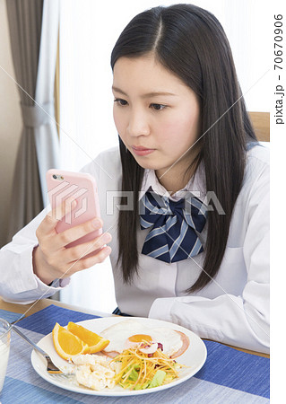 食事しながらスマホを見る女の子 食事しながらスマホを見る女の子 70670906