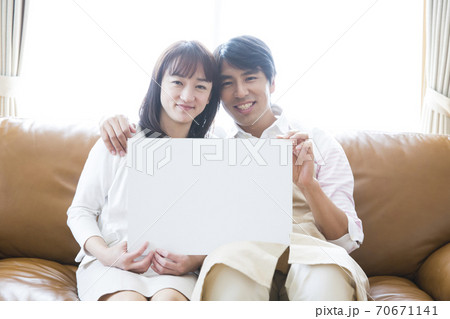 メッセージボードを持つ夫婦 70671141