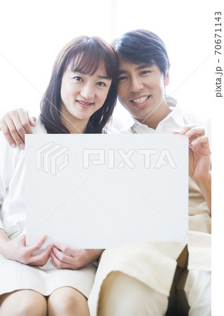 メッセージボードを持つ夫婦 70671143