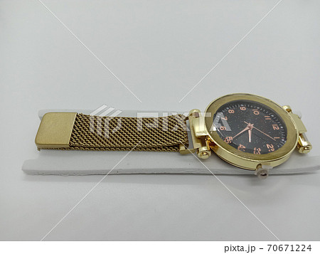 golden colored watch close- up on gray background 70671224