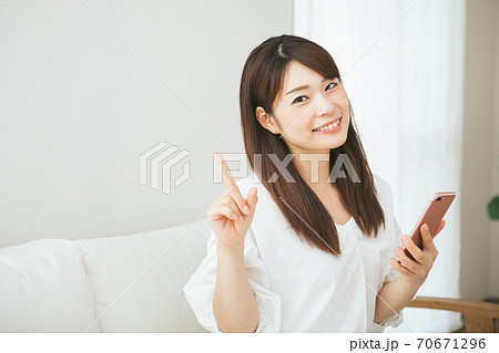 スマホを持って指差しをする女性 スマホを持って指差しをする女性 70671296
