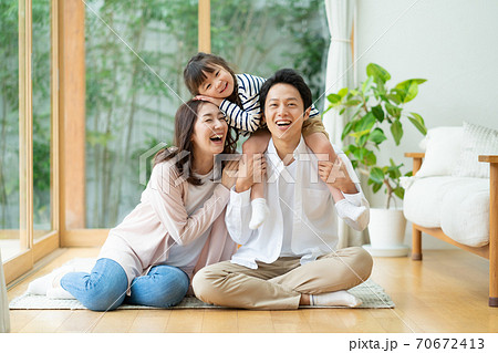 パパに肩車されてふざける女の子とパパとママの3人家族のポートレート 70672413