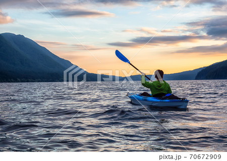 Beautiful View of Person Kayaking on Scenic Lake at Sunset 70672909