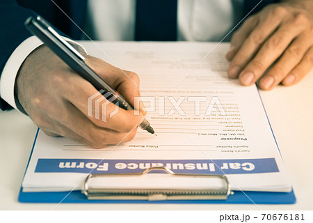 Zoom Insurance Agent Hand Writing Car Insurance Claim Form or Document in Vintage Tone 70676181