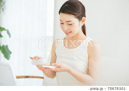 コットンに化粧水を染み込ませる女性 70676301