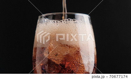 Soda with ice on a black background close-up Soda with ice on a black background close-up 70677174