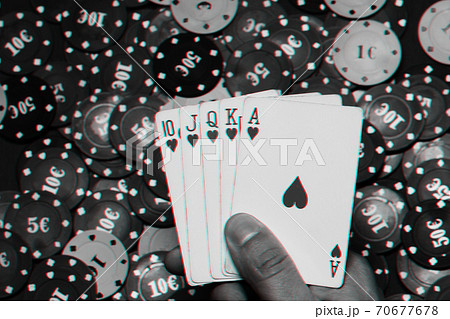 Royal flush in the hands of the player on the background of game chips Royal flush in the hands of the player on the background of game chips 70677678