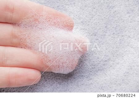 Textured foam on the fingers with bubbles closeup Textured foam on the fingers with bubbles closeup 70680224