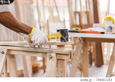 Carpenter use mallet on timber in carpentry workshop. Carpenter use mallet on timber in carpentry workshop. 70681183