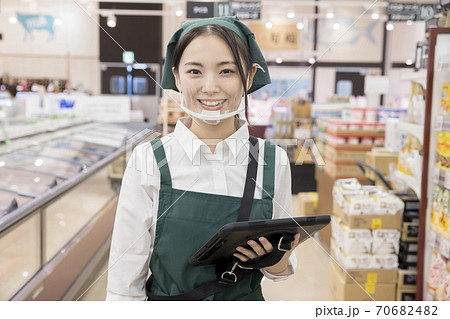 スーパーで在庫管理をするマウスシールドをしたカメラ目線女性従業員 70682482