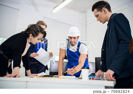 A team of four young architects working on a new project and com 70682824
