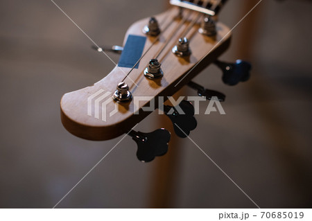 tuning pegs and fretboard bass guitar close up on the background of the musician's apartment with copy space. 70685019