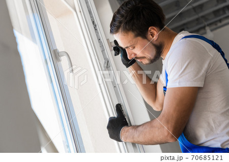 The builder installs a window frame in the room 70685121