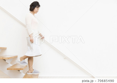 階段を下りるシニア女性 70685490