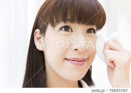 かっさマッサージをする女性 70685597