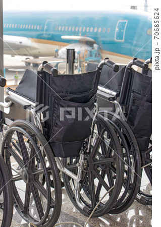 Line of handicapped wheelchairs ready in the airport terminal. Line of handicapped wheelchairs ready in the airport terminal. 70685624