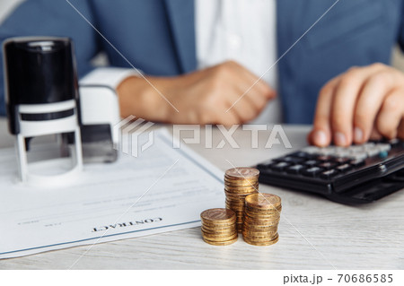 Businessman approves important contract. Stack of coins and stamps on desk. Business concept 70686585