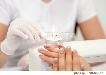 Manicure master is lighting candle 70686644