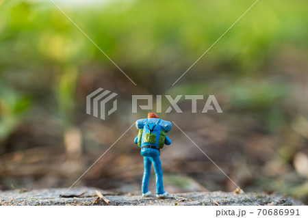 Miniature people : Traveler miniature with backpack stand and walking on meadow Miniature people : Traveler miniature with backpack stand and walking on meadow 70686991