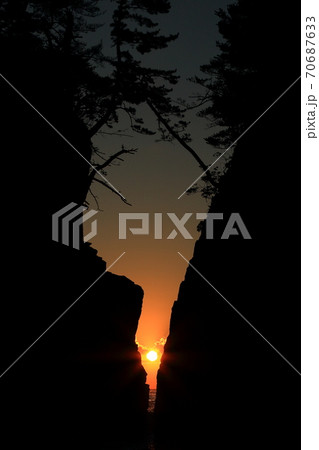 南三陸町神割崎の岩の間から見る太陽 70687633