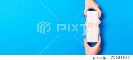Top view of a couple congratulating each other on colorful background. Giving a present. Festive concept. Copy space Top view of a couple congratulating each other on colorful background. Giving a present. Festive concept. Copy space 70688610
