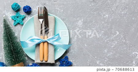 Holiday composition of Christmas dinner on cement background. Top view of plate, utensil and festive decorations. New Year Advent concept with copy space 70688613